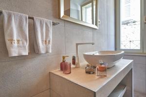 a bathroom with a sink and a mirror and towels at Villa Split Heritage Hotel in Split