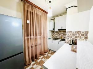 a kitchen with white cabinets and a large window at Modern Elegant Renovated Apartment, New Building, Chekhov stree in Yerevan +20 photos