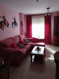 sala de estar con sofá rojo y mesa en La casa de Ainhoa, en Teruel