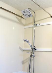 a shower with a shower head in a bathroom at Central London rooms in London