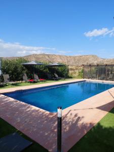una piscina in un cortile con una montagna sullo sfondo di Mas Solana a Huércal-Overa