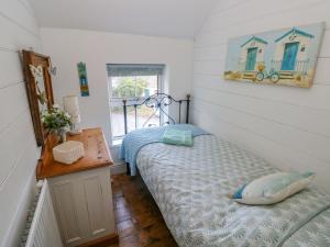 a bedroom with a bed and a table and a mirror at Min Y Ffordd in Goodwick