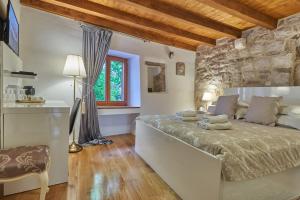 1 dormitorio con 1 cama grande y pared de piedra en Villa Split Heritage Hotel en Split