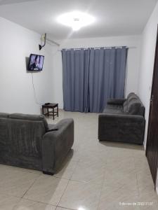 sala de estar con 2 sofás y TV de pantalla plana en Casa Duplex com Vista pro Mar en Guaratuba