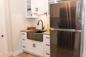 a kitchen with a stainless steel refrigerator and white cabinets at Old Mill Inn in Hatfield
