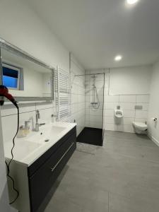 a white bathroom with a sink and a toilet at MR Ferienwohnung - Wohnung Mila 