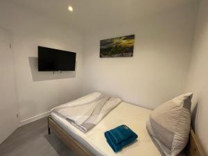 a small bedroom with a bed and a flat screen tv at MR Ferienwohnung - Wohnung Mila 