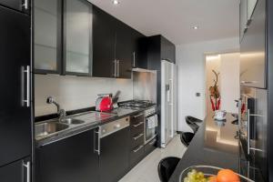 a kitchen with black cabinets and a sink at Casa Sta Clara in Funchal