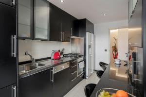 a kitchen with black cabinets and a sink at Casa Sta Clara by An Island Apart in Funchal