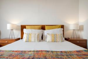 a bedroom with a bed with pillows and two lamps at Casa Sta Clara by An Island Apart in Funchal