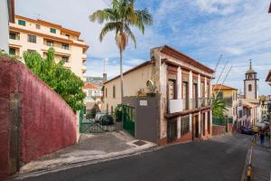 a city street with a building and a palm tree at Casa Sta Clara by An Island Apart in Funchal