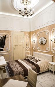 セゲドにあるExclusive Szálláshely Szegedのベッドルーム1室(大型ベッド1台、シャンデリア付)