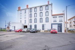 un grupo de coches estacionados frente a un edificio en Agréable et moderne 2 pièces ~ confort et design, en Clermont-Ferrand