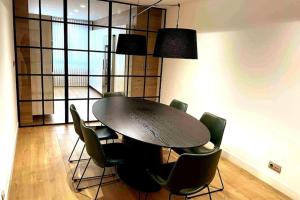 a dining room with a black table and chairs at H7072 Luxury apartments in Santiago de Compostela +12 photos