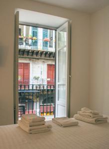 Habitación con cama con ventana y toallas. en Quattrocantiapartments, en Palermo