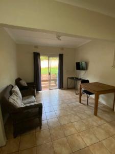 a living room with a couch and a table at Dickens Garden Flat in Empangeni