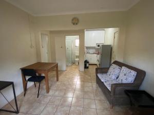 a living room with a couch and a table at Dickens Garden Flat in Empangeni