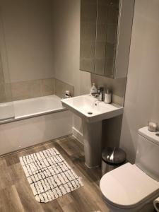 a bathroom with a sink and a toilet and a tub at Cozy room in new build, peaceful village location in Cambridge