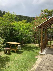 un tavolo da picnic e una panchina in un cortile di SURF PARADISE apartamentos a Pinheira