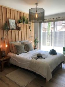 a bedroom with a large bed with two hats on it at Nanie - Villa centre-ville, piscine, wifi - La Teste de Buch in La Teste-de-Buch