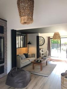 a living room with a couch and a table at Nanie - Villa centre-ville, piscine, wifi - La Teste de Buch in La Teste-de-Buch