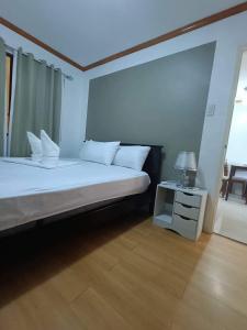 a bedroom with a bed and a table with a lamp at Alles One Oasis Condo Davao Near SM Mall with Wifi in Davao City