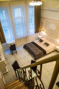 een slaapkamer met een groot bed in een kamer met ramen bij Exclusive Apartmanok Szeged in Szeged