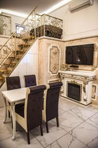 une salle à manger avec une table, des chaises et une cheminée dans l'établissement Exclusive Apartmanok Szeged, à Szeged