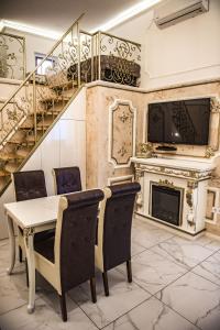 una sala da pranzo con tavolo, sedie e camino di Exclusive Apartmanok Szeged a Szeged