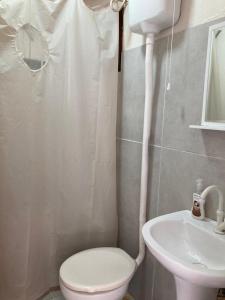 La salle de bains est pourvue de toilettes et d'un lavabo. dans l'établissement SURF PARADISE apartamentos, à Pinheira