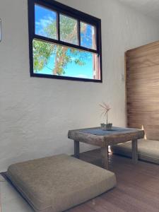 a room with a bench and a table and a window at SURF PARADISE apartamentos in Pinheira