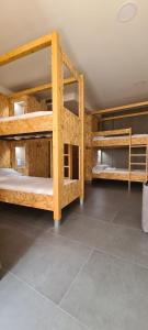 a room with three bunk beds and a tile floor at LUMEN ALBERGUE in Mondoñedo