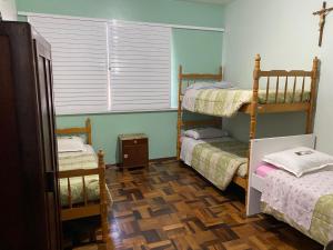 Habitación con 2 literas y ventana en Pousada Irmãs Franciscanas, en Lages