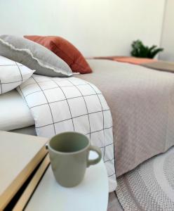 a cup of coffee on a table next to a bed at Beautiful studio in the heart of Lahti in Lahti