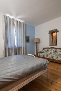 a bedroom with a bed and a couch and a window at Rooms Relais Art Borgocastello3 in Gorizia