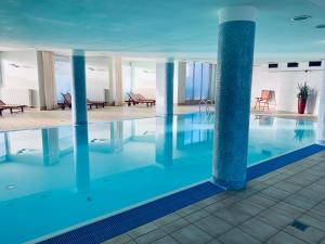 a large swimming pool with blue water in a building at City view Apartment in Krakow
