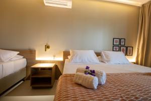 a hotel room with two beds with towels on the bed at Ipioca Beach Resort in Ipioca