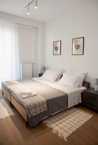 een slaapkamer met een groot bed met witte muren bij Glyfada Downtown in Athene