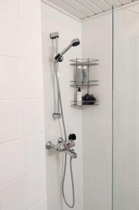 a shower with a shower head in a bathroom at Beautiful studio in the heart of Lahti in Lahti