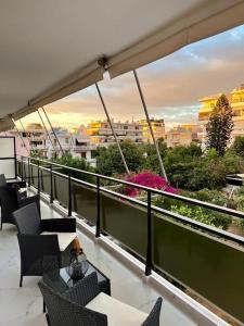 a balcony with chairs and tables and a view of a city at Glyfada Downtown in Athens