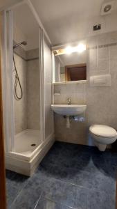 bagno con lavandino, doccia e servizi igienici di Appartamento Fiocco Di Neve a Campitello di Fassa