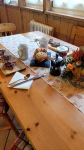 uma mesa de madeira com comida e utensílios em Appartamento Fiocco Di Neve em Campitello di Fassa