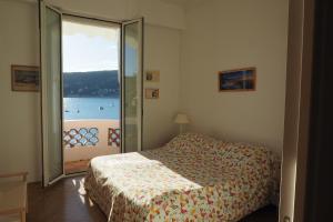 a bedroom with a bed and a view of the water at Villa la Felicite in Saint-Jean-Cap-Ferrat