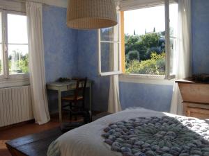 a bedroom with a bed and a table and windows at maison florentine in La Gaude +20 photos