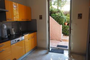 een keuken met oranje kasten en een deur naar een patio bij Villa la Felicite in Saint-Jean-Cap-Ferrat