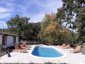 a swimming pool with lounge chairs and a swimming pool at Gîte en pleine nature, A la douceur des Chênes in Maubec