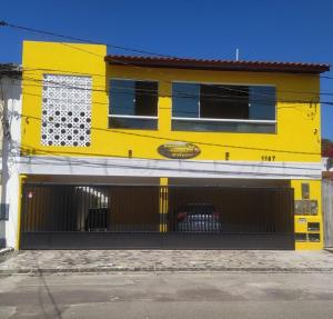 a yellow building with a black gate in front of it at Residencial Sol Nascente in Aracaju