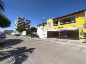 a yellow building on the side of a street at Residencial Sol Nascente in Aracaju