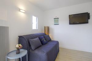 sala de estar con sofá azul y TV en Large studio with ocean view 5 min to Anglet beach - Welkeys, en Anglet
