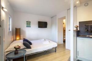 1 dormitorio con 1 cama y TV en la pared en Large studio with ocean view 5 min to Anglet beach - Welkeys, en Anglet